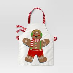 a white apron with a gingerbread man on it and candy canes around the neck