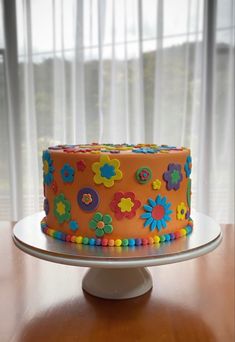 a brightly colored cake sitting on top of a wooden table