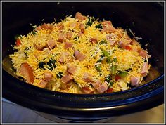 a crock pot filled with ham and cheese on top of a stove burner