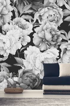 a black and white floral wallpaper with large flowers on the side, next to a couch