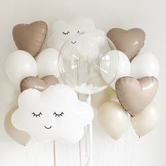 a bunch of balloons that are in the shape of clouds with eyes and noses on them