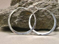 These continuous hoops are hammered and formed for comfort with an easy, secure post closure that is soldered to one end and slips into a drilled opening at the other.  They are hand forged by me with pride and attention from 13 gauge sterling wire, so they're sturdy but not heavy. Just the first in a new line of clean, self locking hoops that you'll never take off.  1 1/2  or 2 inches in (outer) diameter.  Select size in dropdown menu. If you don't see the size you want, convo me for custom sizes and pricing. Please allow 10 days for fabrication. My usual fabrication time is 5-10 days, although I sometimes have this item in stock.  If you absolutely need it sooner, please convo me and I'll do what I can to expedite.  I'm a 1-person shop, and I fabricate, finish, pack, and ship and each it Hammered Artisan Hoop Earrings For Everyday, Artisan Hammered Round Hoop Earrings, Artisan Hammered Hoop Earrings For Everyday, Everyday Artisan Hammered Hoop Earrings, Artisan Small Hoop Hand Forged Earrings, Artisan Hand Forged Small Hoop Earrings, Open Hoop Earrings, Artisan Earrings, Opal Earrings