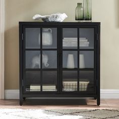 a black cabinet with glass doors in a living room