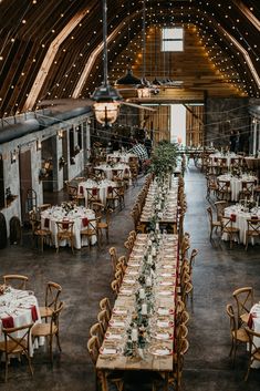 the inside of a barn with tables and chairs set up for an elegant wedding reception