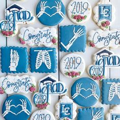 decorated cookies are arranged in the shape of heart, hand, and bones with congratulations written on them