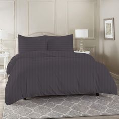 a bed in a room with a gray comforter