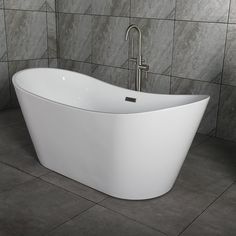 a large white bathtub sitting on top of a tiled floor next to a wall