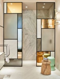 the interior of a bathroom with marble walls and flooring, along with glass partitions