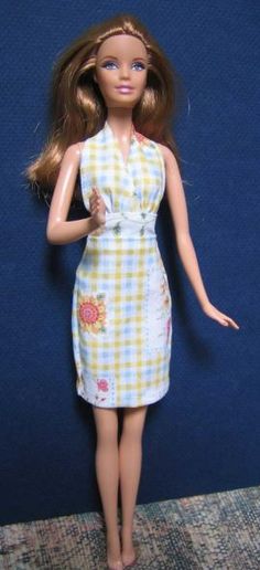 a barbie doll wearing a yellow and white dress