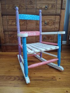 a child's rocking chair with polka dots on the bottom and pink, blue, and white trim