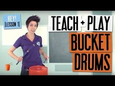 a woman standing in front of a bucket holding a knife and orange cup with the words teach play bucket drums