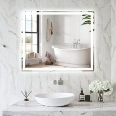 a bathroom with a sink, mirror and bathtub in the middle of the room