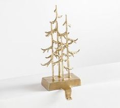 a small gold christmas tree on a marble base with no leaves or branches in it