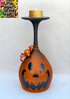 an orange and black vase with a jack - o'- lantern candle holder on it