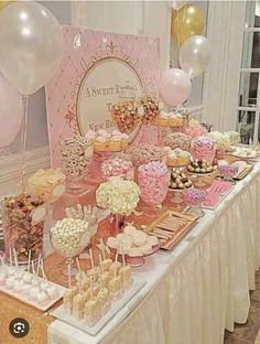 a table topped with lots of desserts and balloons