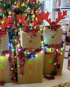 three brown bags with reindeer faces on them are decorated in christmas lights and garlands