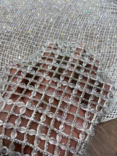 a close up of a person's hand holding some glass beads on a cloth