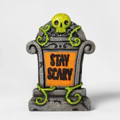 a halloween decoration with a sign that says stay scary and a skull sitting on top