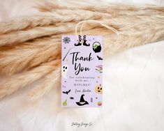 a thank you tag hanging from a furnishing on a white bed with halloween decorations