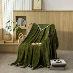 a green blanket sitting on top of a wooden table