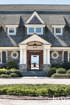 the front entrance to a large house with landscaping around it