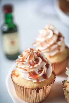 three cupcakes with white frosting and caramel drizzle