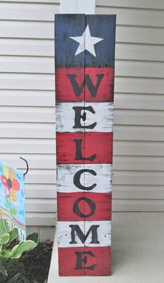 a wooden sign that says welcome home with an american flag painted on the front and side