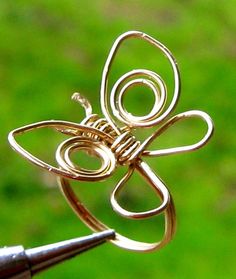 a close up of a metal object with scissors in the foreground and grass in the background