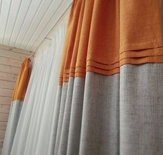 an orange and grey curtain is hanging on the wall