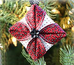 a red and white ornament hanging from a christmas tree with the words cathedral window christmas ornament diy