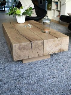 a coffee table made out of wooden planks with flowers in the center and candles on top