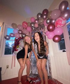 two young women posing in front of balloons