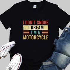 "Rev up your wardrobe with our funny \"I Don't Snore, I Dream I'm a Motorcycle\" biker shirt. This high-quality, comfortable tee is a top gear choice for any motorcycle rider, sure to add horsepower to your style. Decked in colorful, vibrant text, this men's shirt isn't just a piece of clothing, it's a conversation starter. Whether you're thundering down the highway or kicking back at a local café, it's designed to get laughs and admiring nods from fellow bikers and friends alike. Seeking the pe Cotton Biker T-shirt With Letter Print, Cotton Biker Tops With Letter Print, Biker Style Cotton T-shirt With Letter Print, Motorcycle Funny, Gift For Biker, Bike Rally, Biker Shirts, Motorcycle Tshirts, Motorcycle Riders