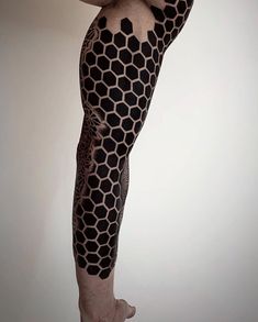 a man with tattoos on his legs and leggings is posing for the camera