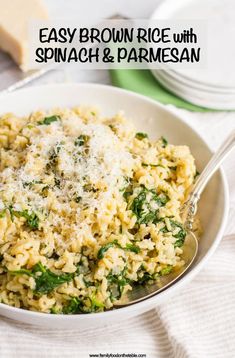 a white bowl filled with spinach and parmesan rice on top of a table