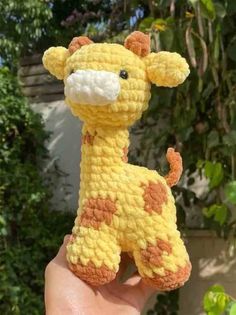 a crocheted giraffe is shown in the palm of someone's hand