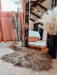 a large mirror sitting on top of a floor next to a vase filled with plants