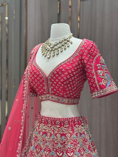 Unleash your inner thrill-seeker with our JUNE MADNESS ONLINE EXCLUSIVE-011! This bold rani pink bridal lehenga is adorned with gottapatti work and intricate blue and sage green thread work. The sliver zardozi sequin and pearl details add a touch of daring to this perfect look. Fabric: Raw Silk! WASH CARE INSTRUCTIONS - Please Dry clean only when it is applicable. Ready to Ship! Red Raw Silk Choli With Mirror Work, Kundan Embellished Lehenga For Festivals, Embellished Kundan Lehenga For Festivals, Festive Kundan Embellished Lehenga, Red Lehenga With Mirror Work In Chinon, Festival Embellished Kundan Choli, Red Embellished Sharara In Kundan Material, Embellished Raw Silk Traditional Wear In Red, Embellished Raw Silk Red Traditional Wear