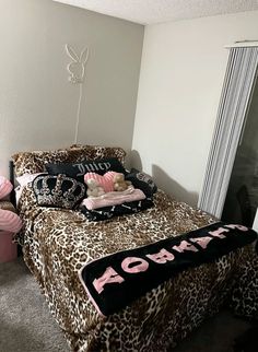 a leopard print bed in a bedroom with pink and black accessories on the bedspread