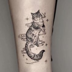 a black and white cat sitting on the back of a woman's leg with stars around