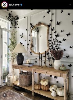 a living room with a mirror and many bats on the wall next to a table