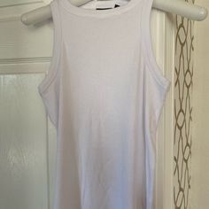 a white tank top hanging on a door