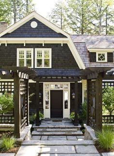 a black and white house with stone steps leading to the front door