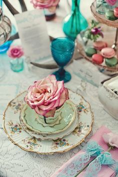 a pink rose sitting on top of a green plate