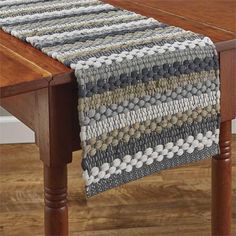 a wooden table with a knitted runner on it