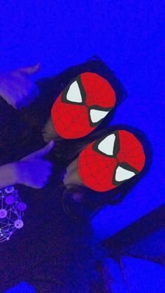 two people wearing spider - man masks on their faces