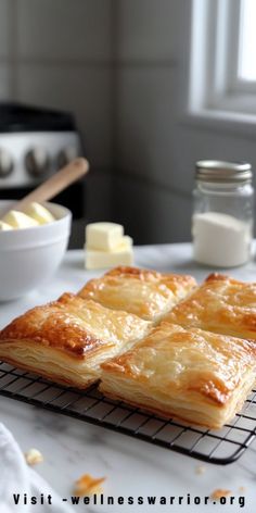 some food is sitting on a cooling rack next to a bowl of butter and other ingredients