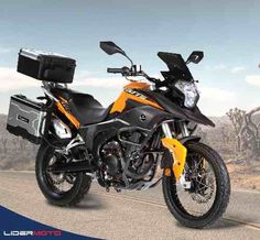 an orange and black motorcycle parked on the side of a road with mountains in the background