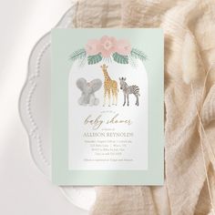 a baby shower with an elephant, giraffe and zebra in the background on a plate