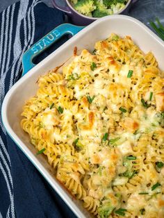 a casserole dish with broccoli and chicken in it on a blue towel